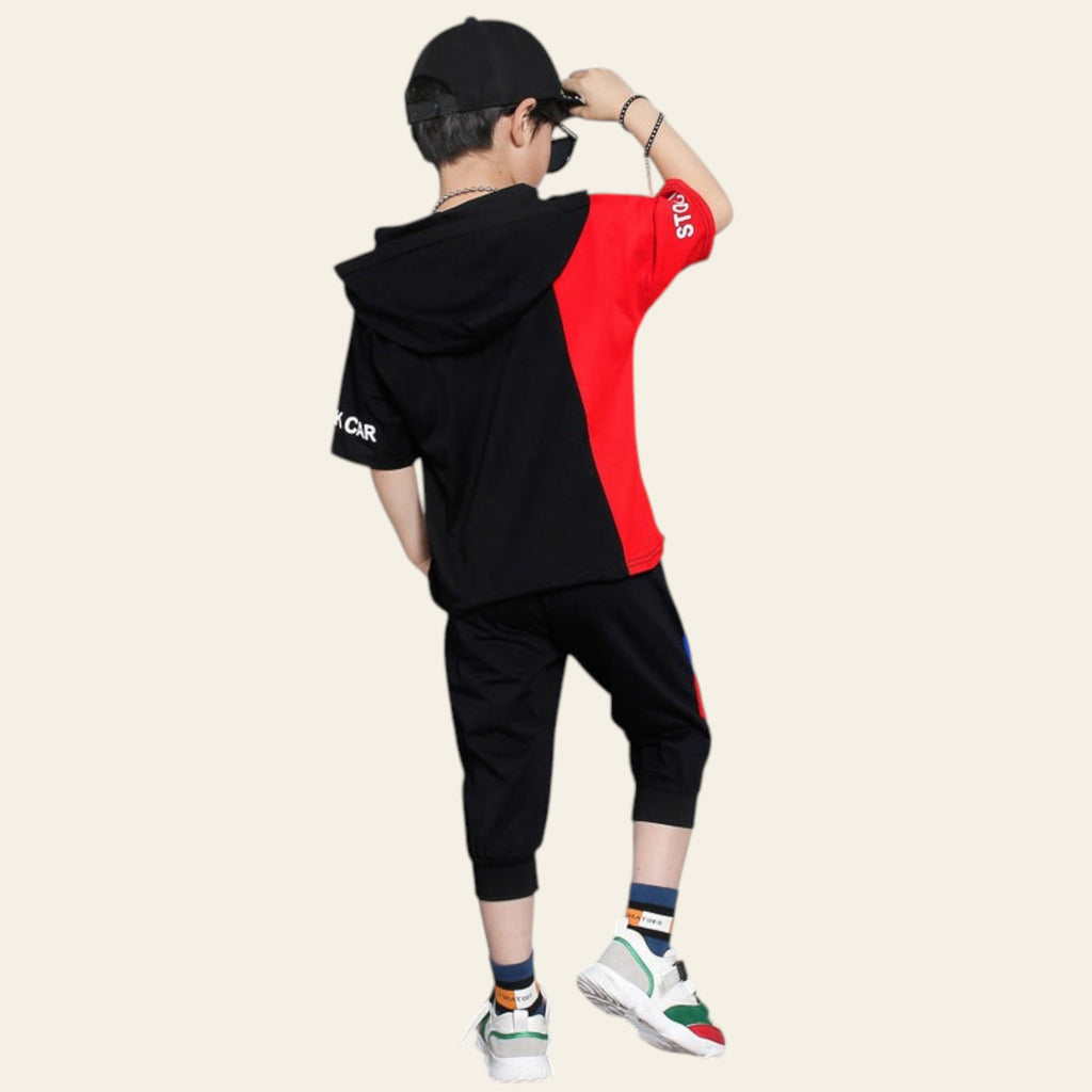Person wearing a black and red hoodie with a skateboard on a gray background