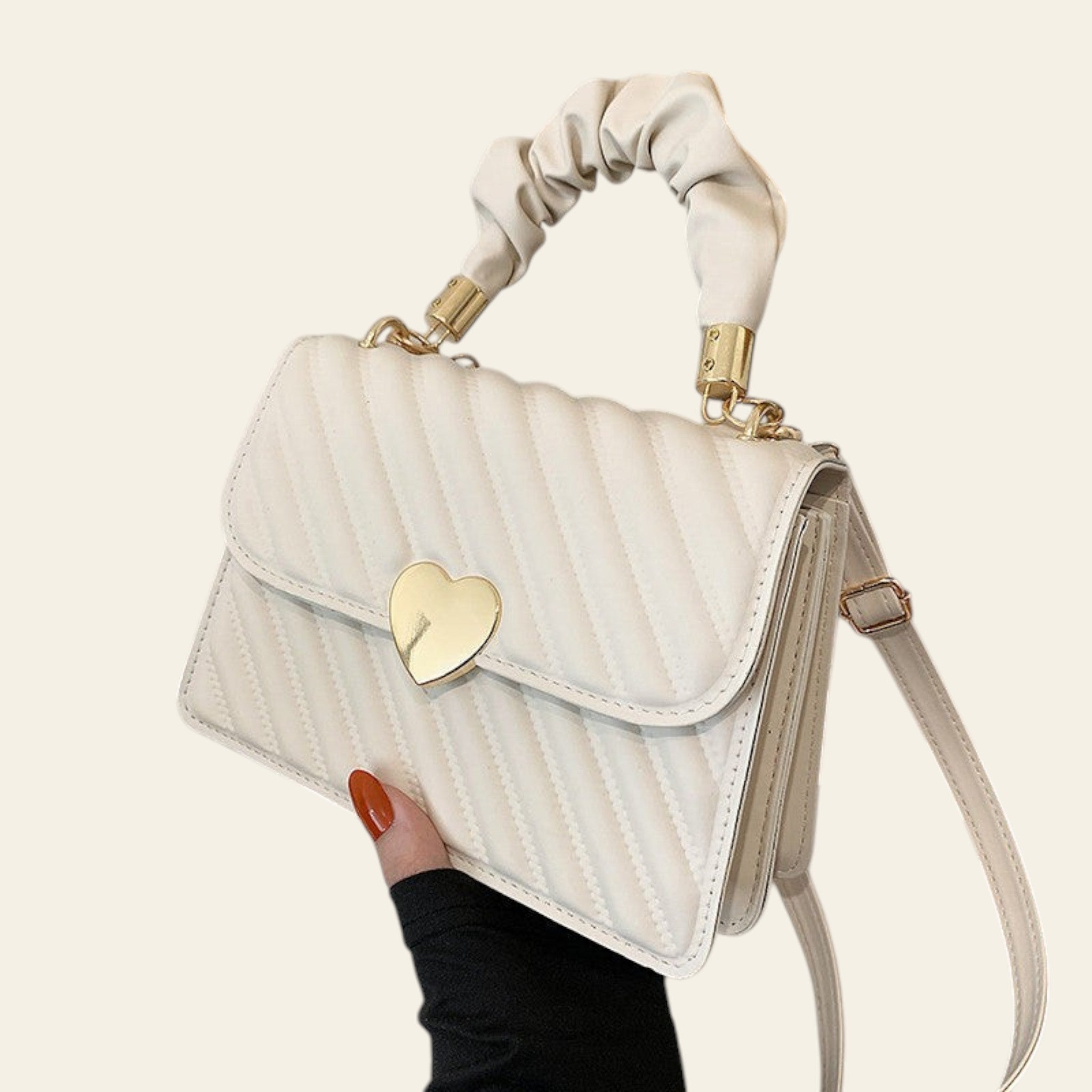 White handbag with a gold heart lock held by a hand on a magazine