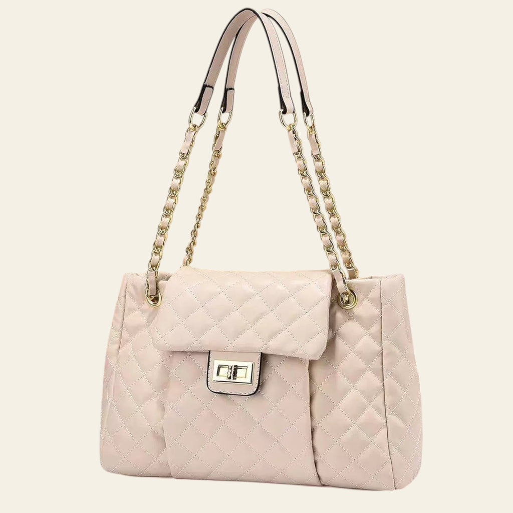 Quilted beige handbag with chain strap on a beige background