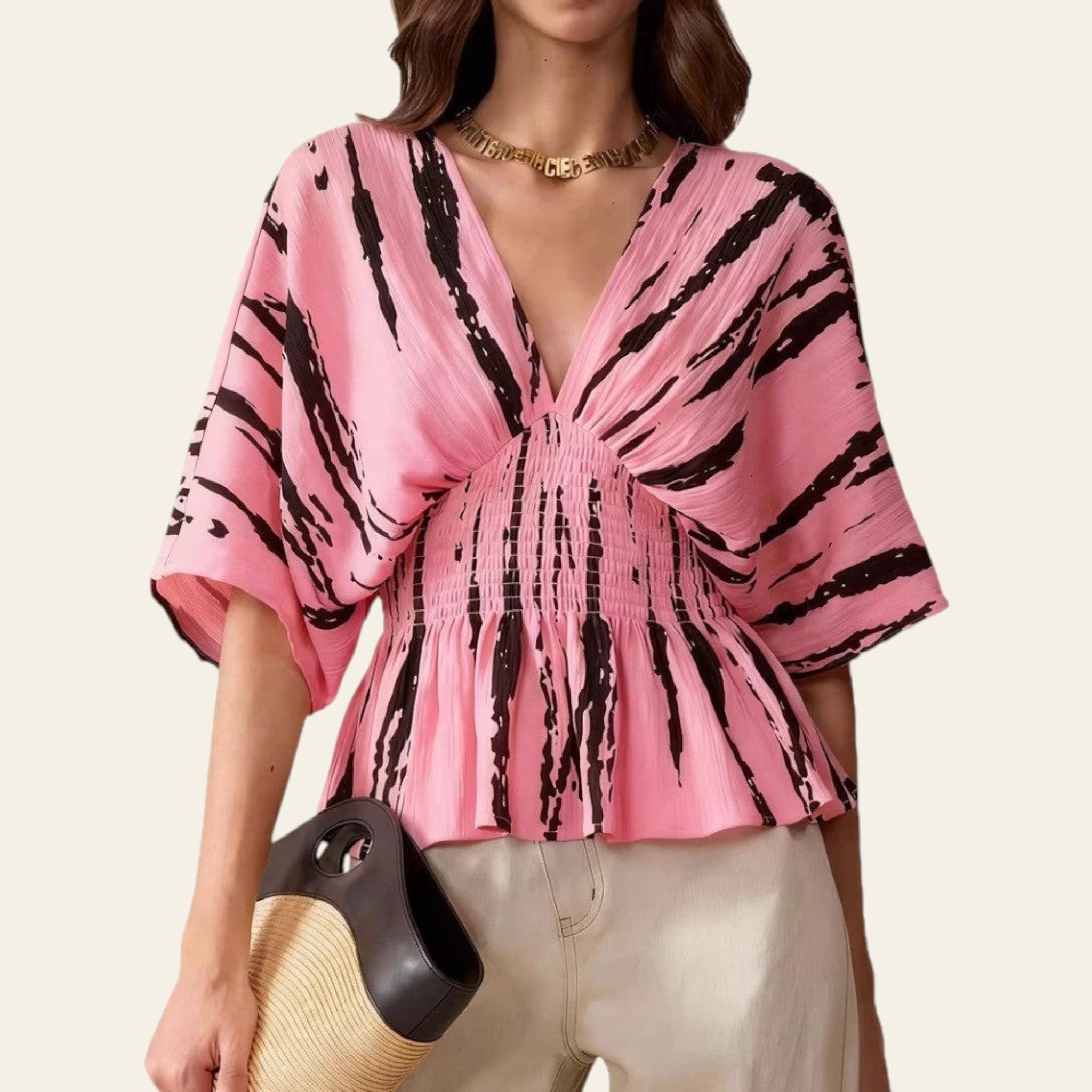 Woman wearing a pink and black patterned blouse with a white background
