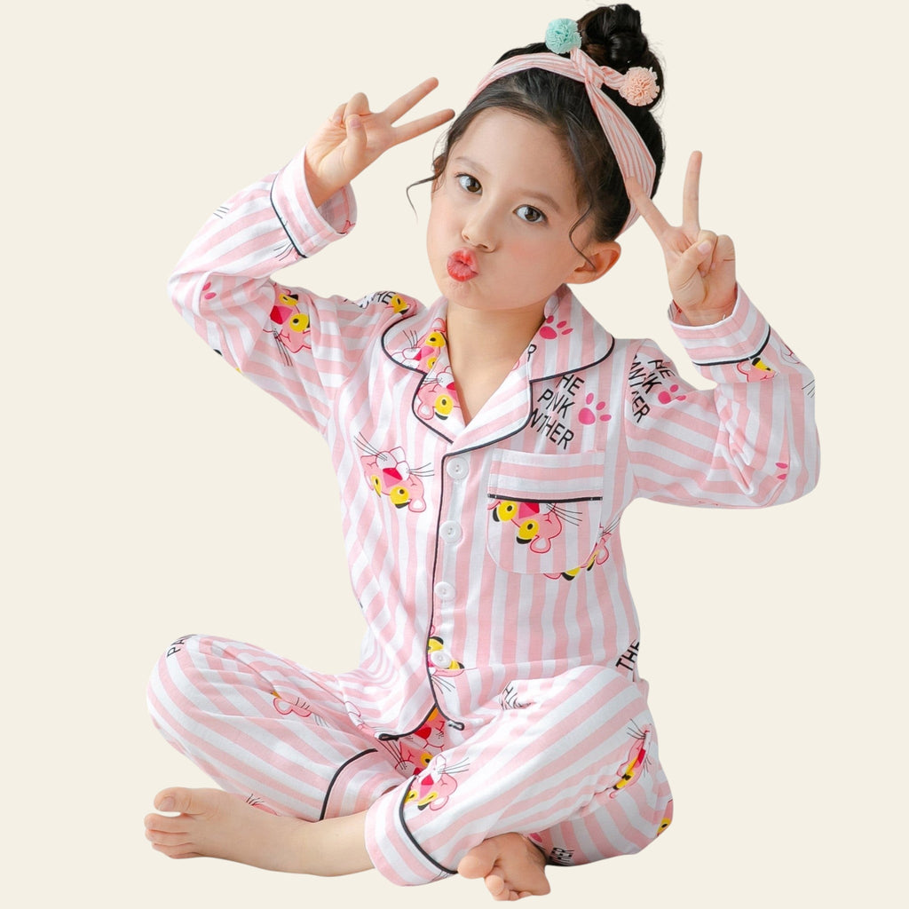 Child wearing pink striped pajamas with cartoon characters, making peace signs.