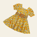 Yellow floral dress with a belt on a beige background