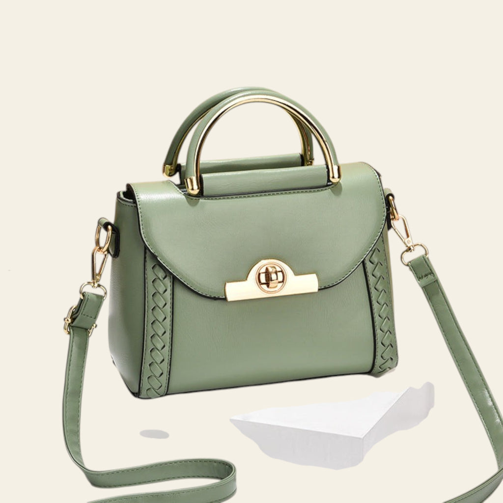 Green handbag with gold accents on a beige background