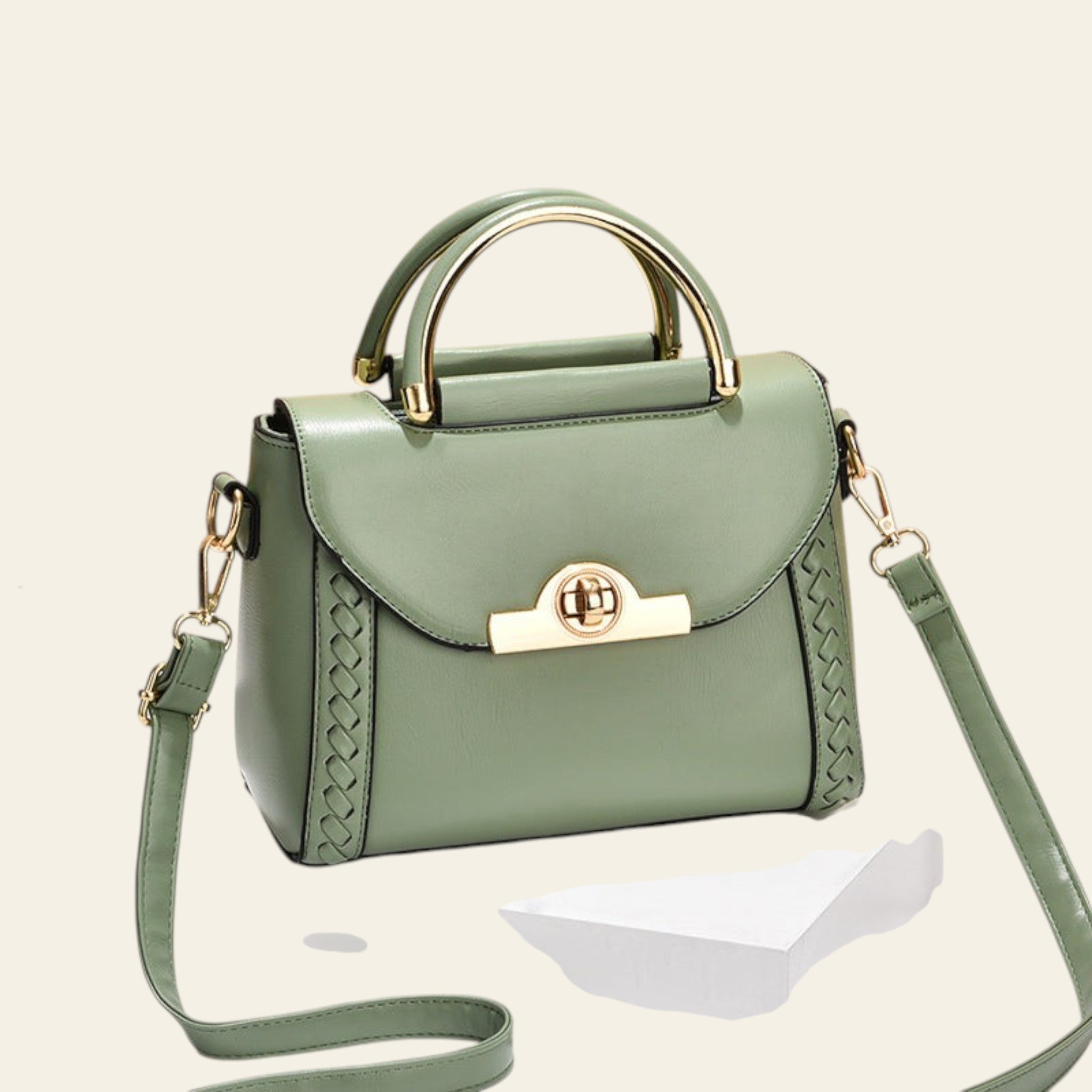 Green handbag with gold accents on a beige background