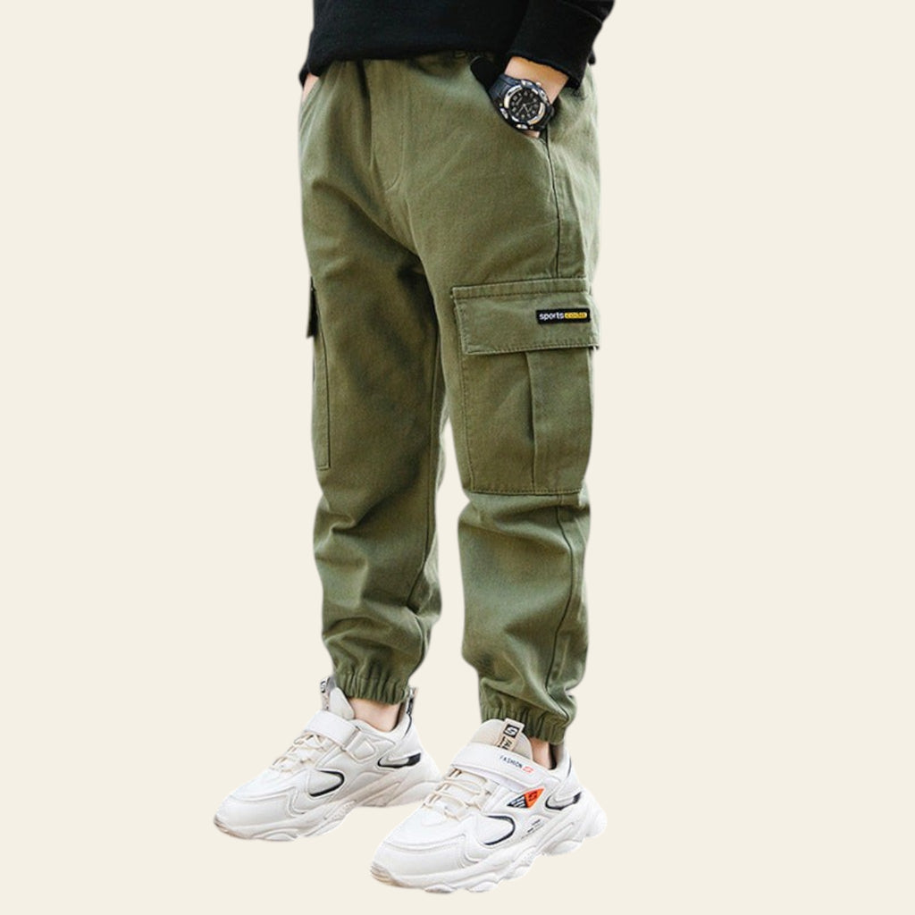 Person wearing green cargo pants and white sneakers on a street.