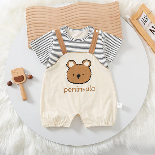 Baby outfit with striped shirt and bear-themed overalls on a white surface