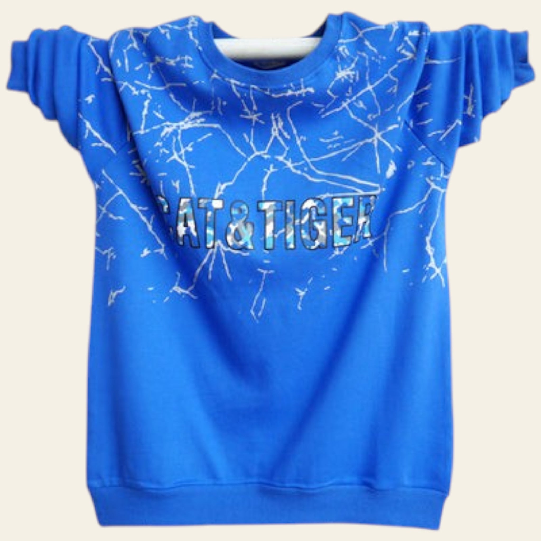 Blue sweatshirt with white abstract design and 'CAT & TIGER' text on a white wooden background