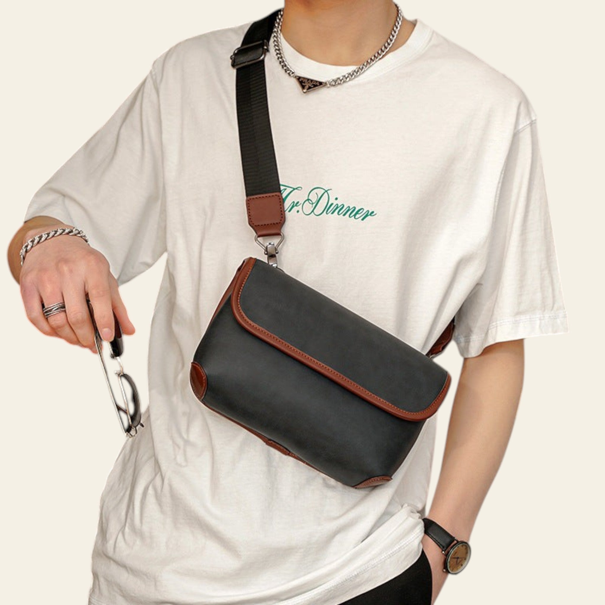Person wearing a white t-shirt with 'Dr. Diner' text, holding a black and brown crossbody bag.