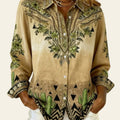 Beige embroidered shirt with cactus design worn by a person indoors.
