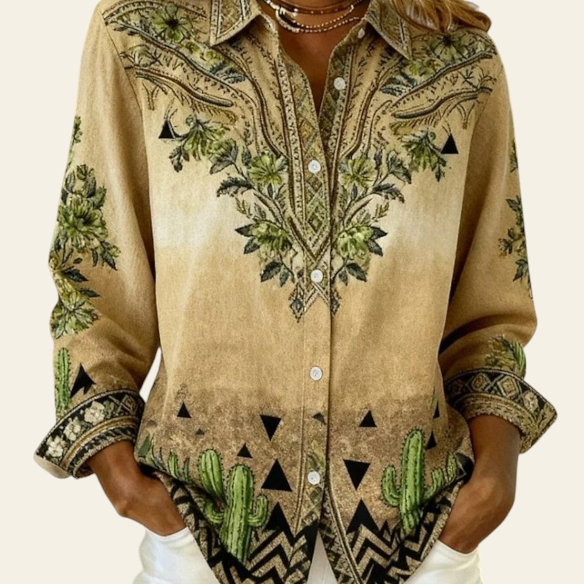 Beige embroidered shirt with cactus design worn by a person indoors.