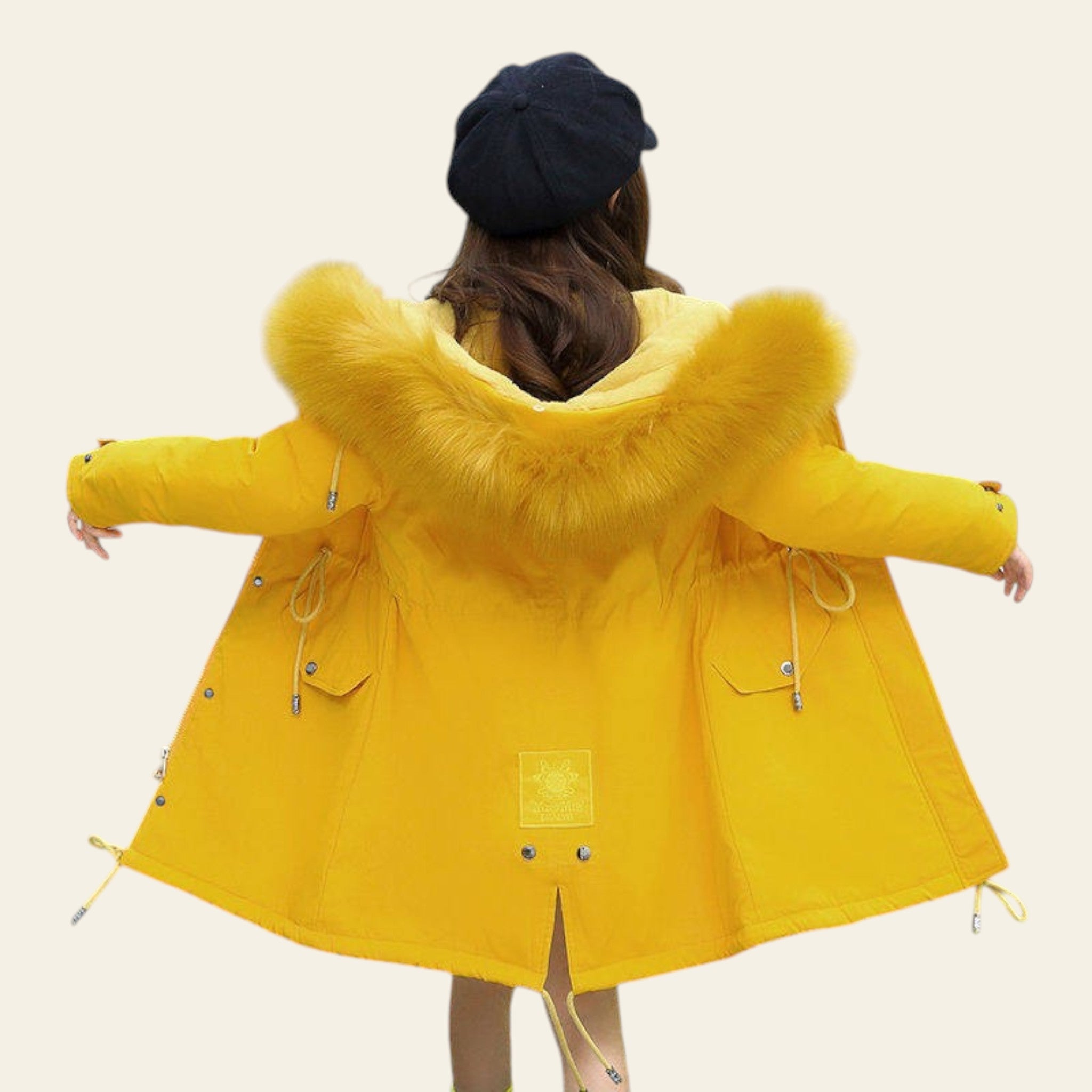 Person wearing a yellow coat with a fur-lined hood on a city street.