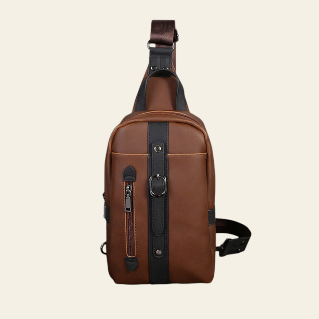 Brown leather sling bag with black straps on a white background