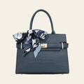 Blue textured handbag with a decorative scarf on a white background
