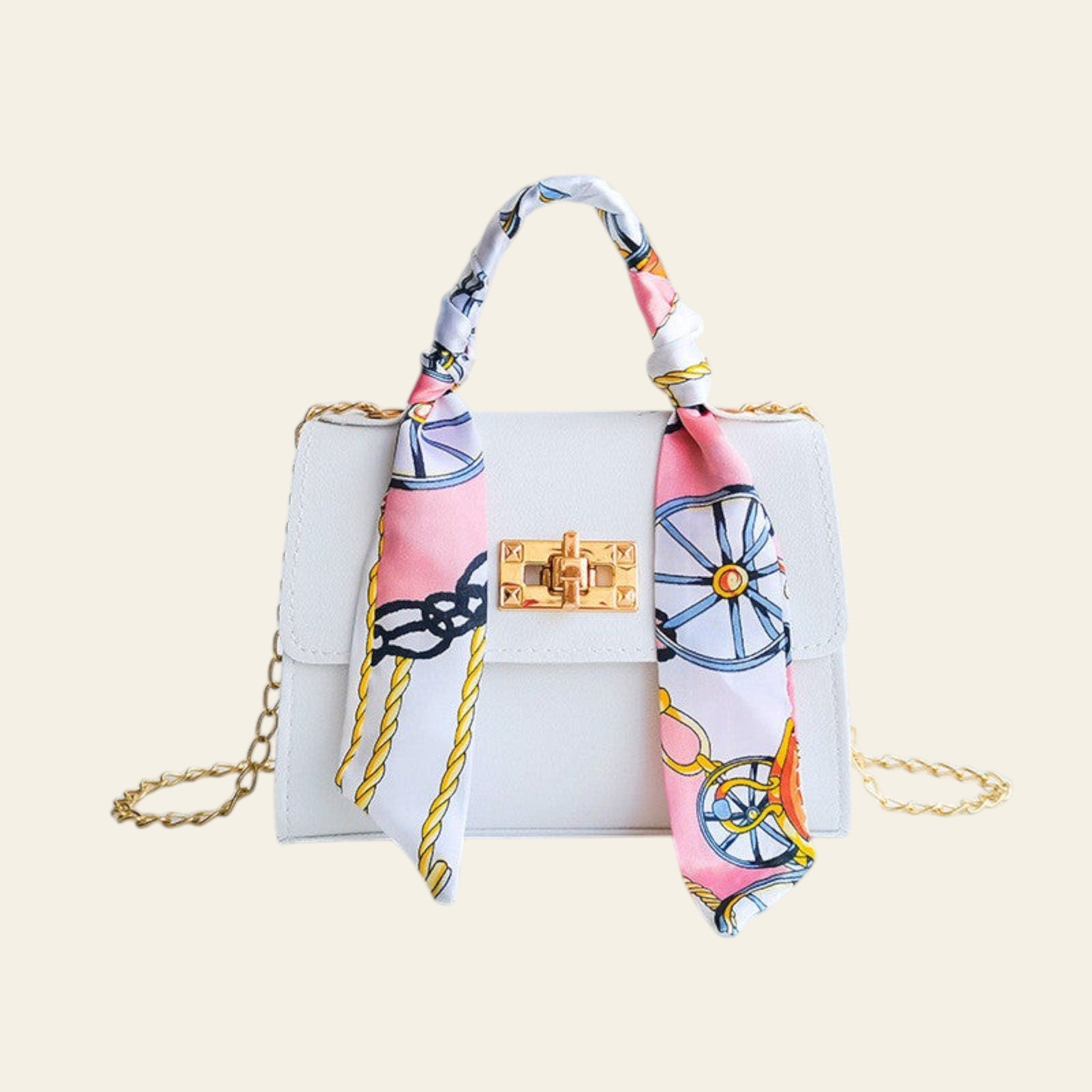 White handbag with a decorative pink and blue scarf draped over it on a light gray background