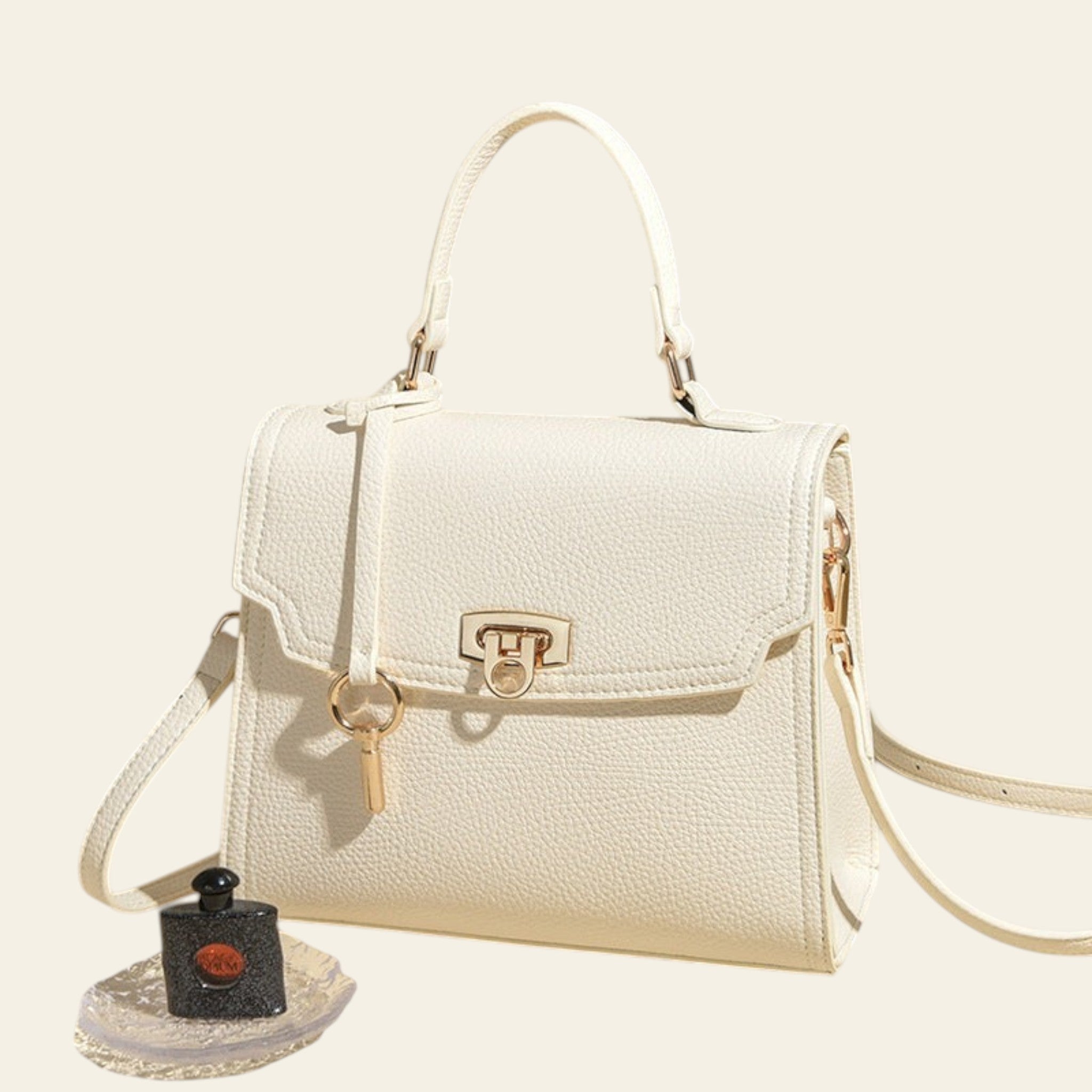 White handbag with a small black bottle on a beige background