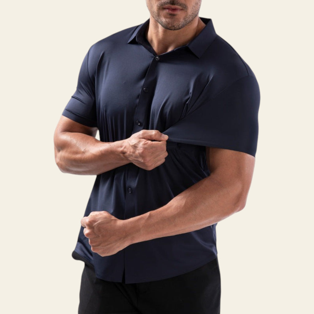 Man wearing a navy blue polo shirt against a light gray background