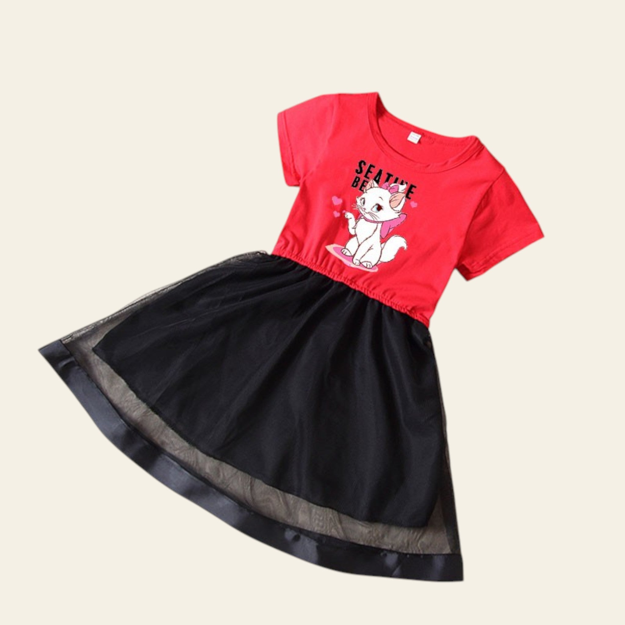 Red top with cartoon character and black skirt on a beige surface