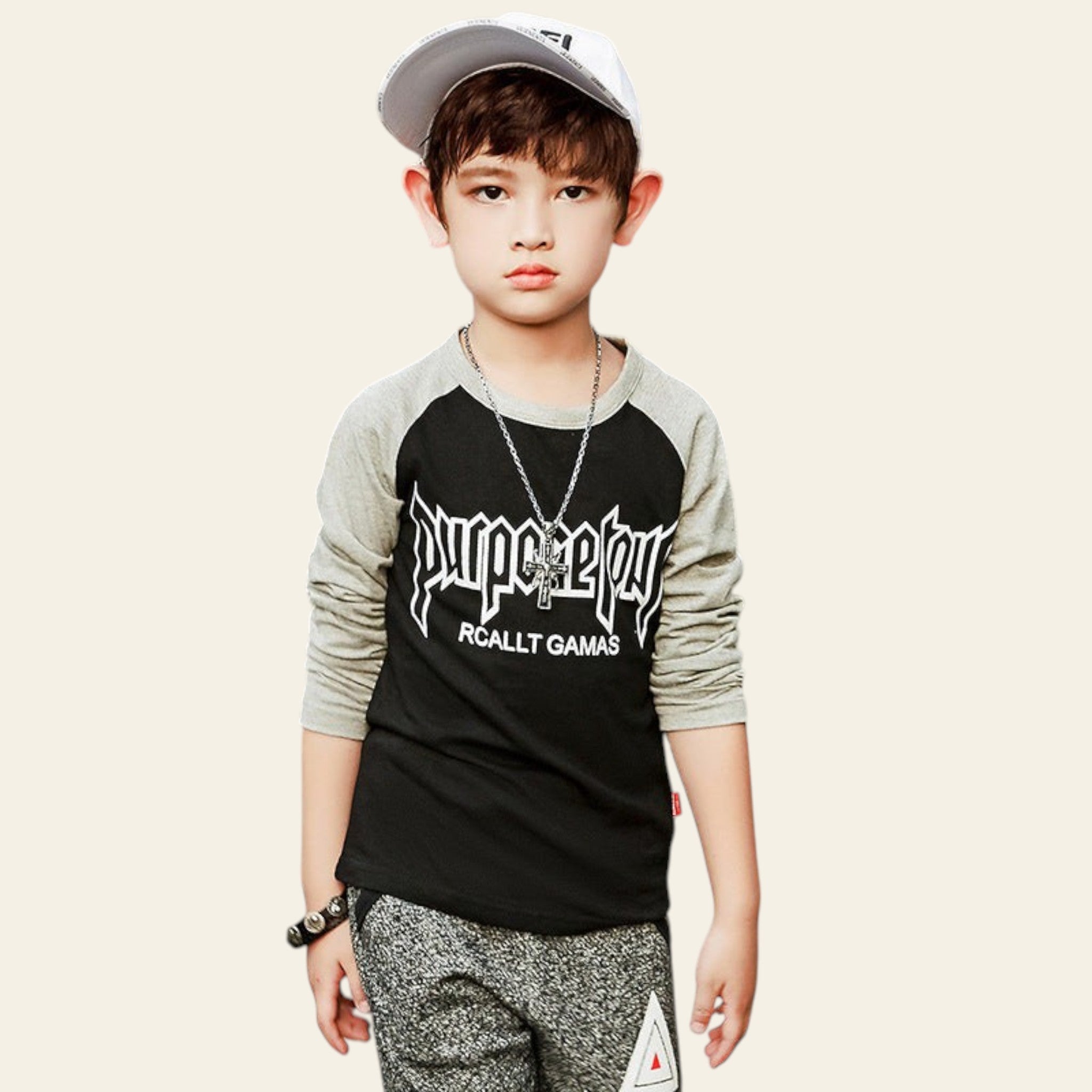 Child wearing a black and gray long-sleeve shirt with text on a street.
