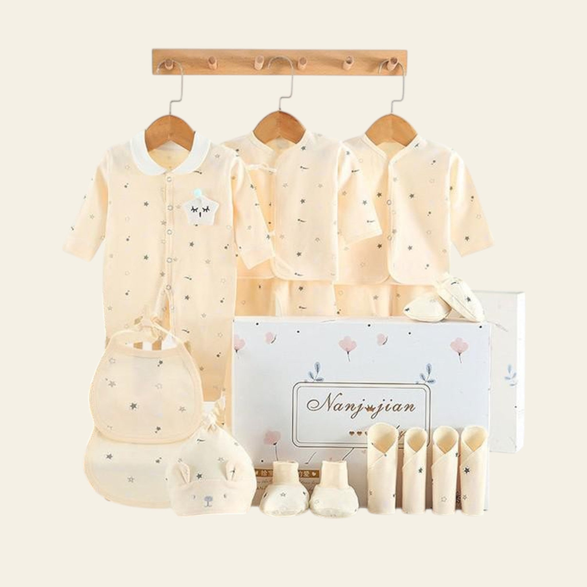 Baby clothing set with matching bag and shoes displayed on hangers against a white background.