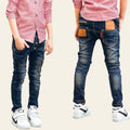 Two pairs of blue jeans worn by people on a blurred background