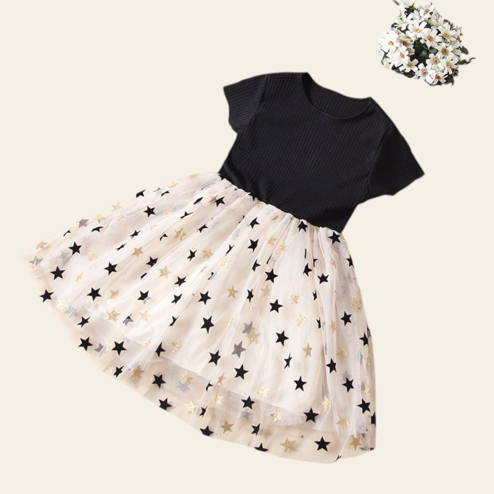 Black top and white skirt with star pattern on a beige surface