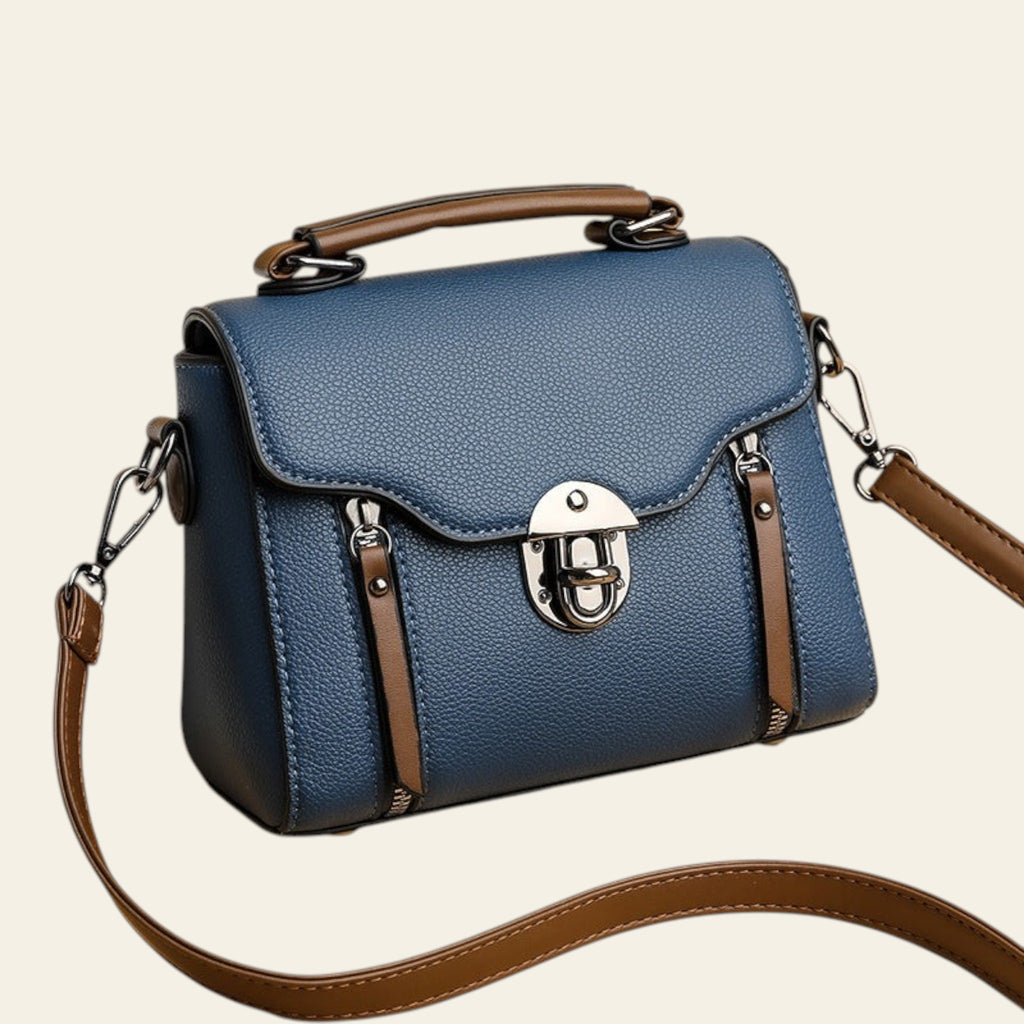 Blue handbag with brown straps on a beige background