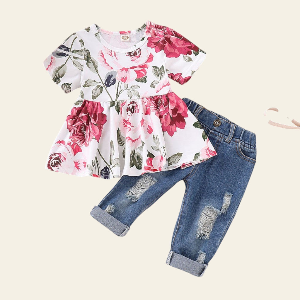 Floral top and denim pants set on a pink background