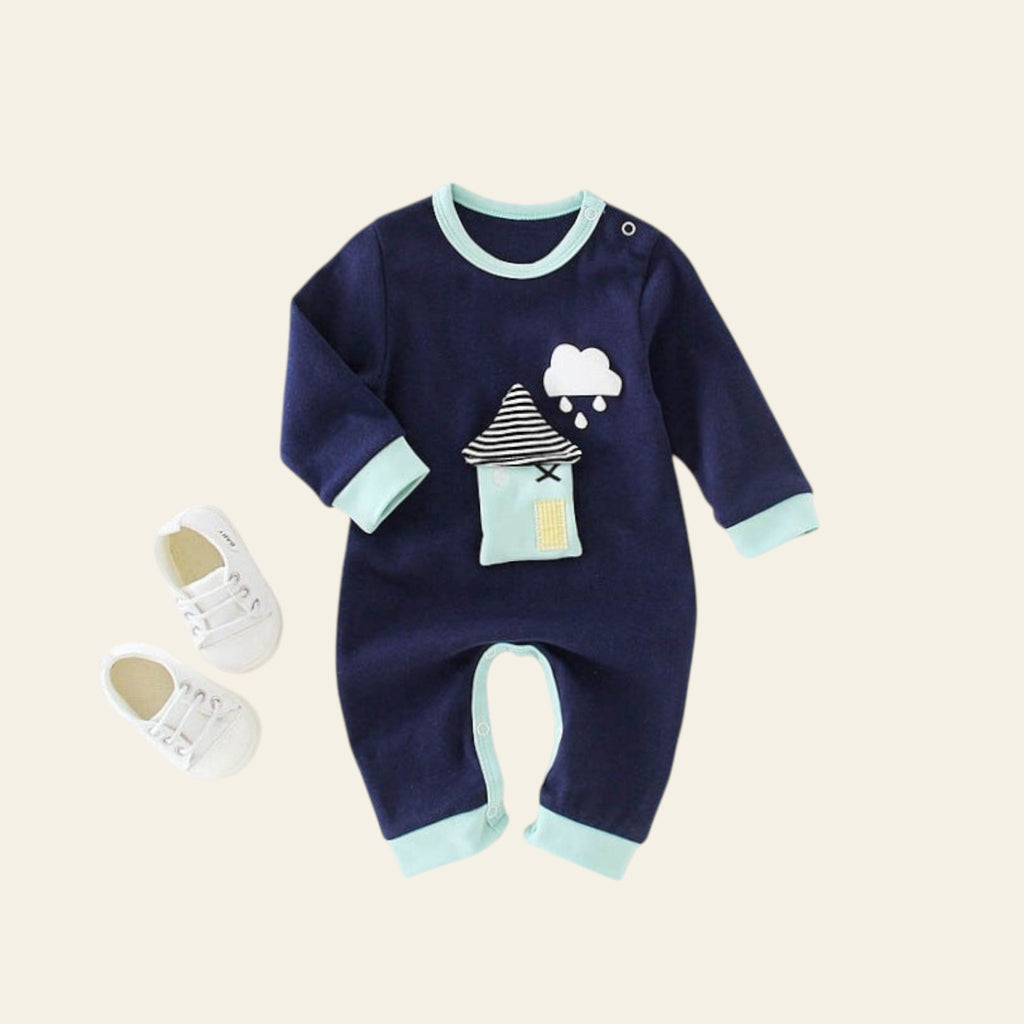 Navy baby romper with cloud and house design on a white surface