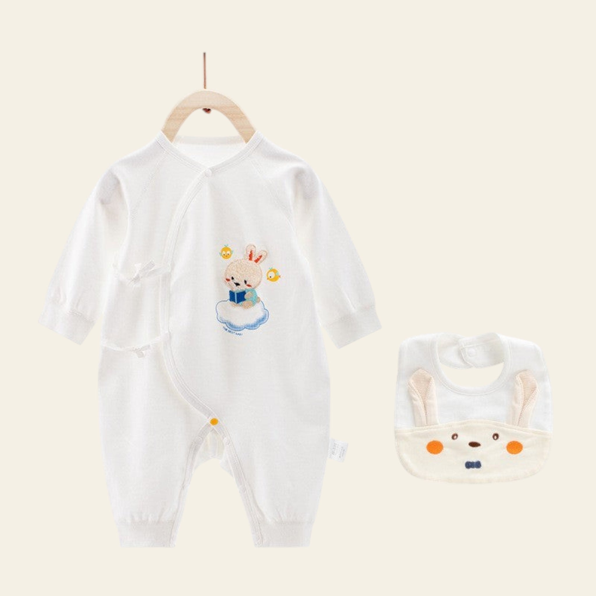 White baby onesie with cartoon design and matching bib on a white background