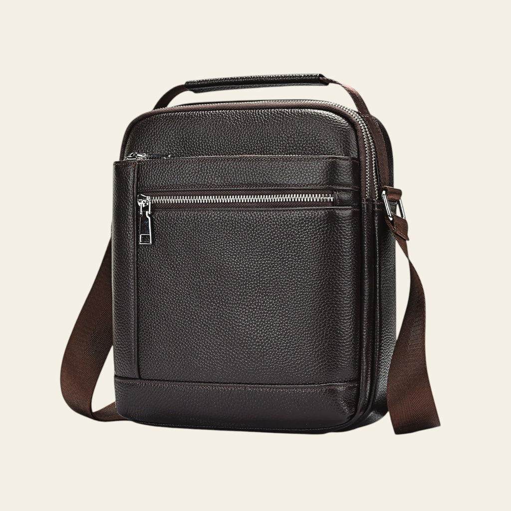 Brown leather crossbody bag on a light blue background