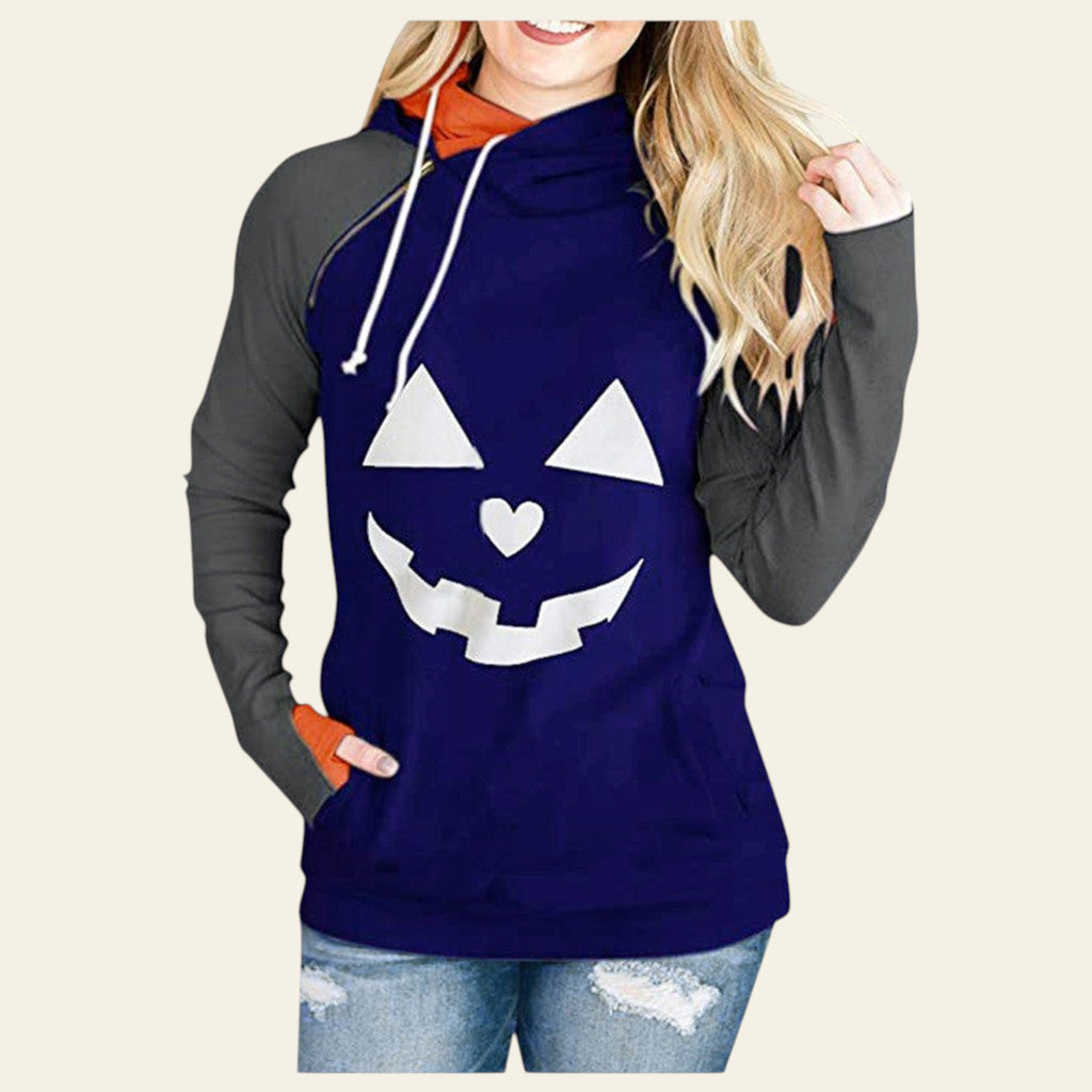 Blue hoodie with pumpkin face design worn by a person on a white background