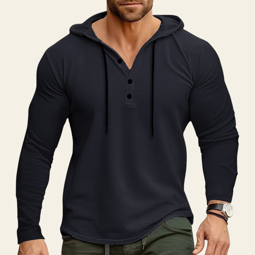 Man wearing a black long-sleeve henley shirt with a blurred background