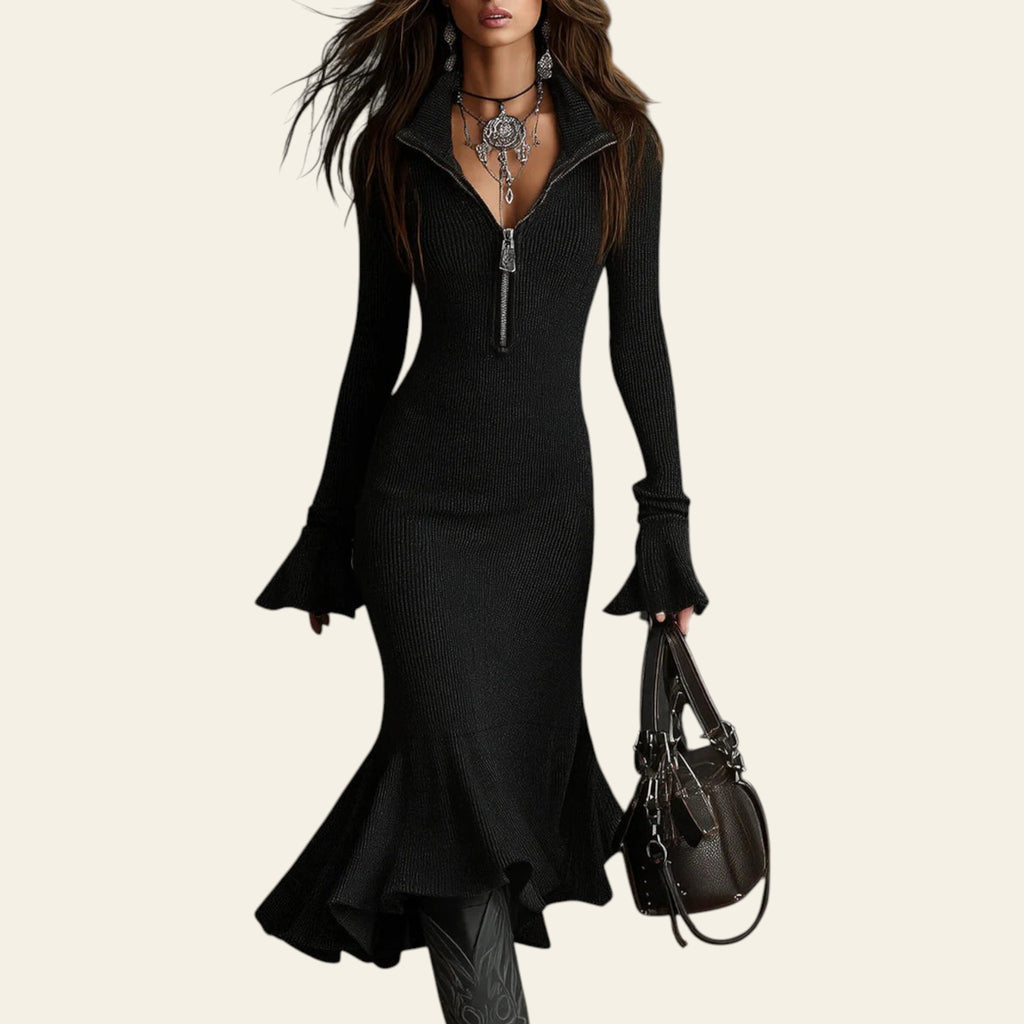 Woman wearing a black pleated V-neck knitted mermaid dress against a gray background