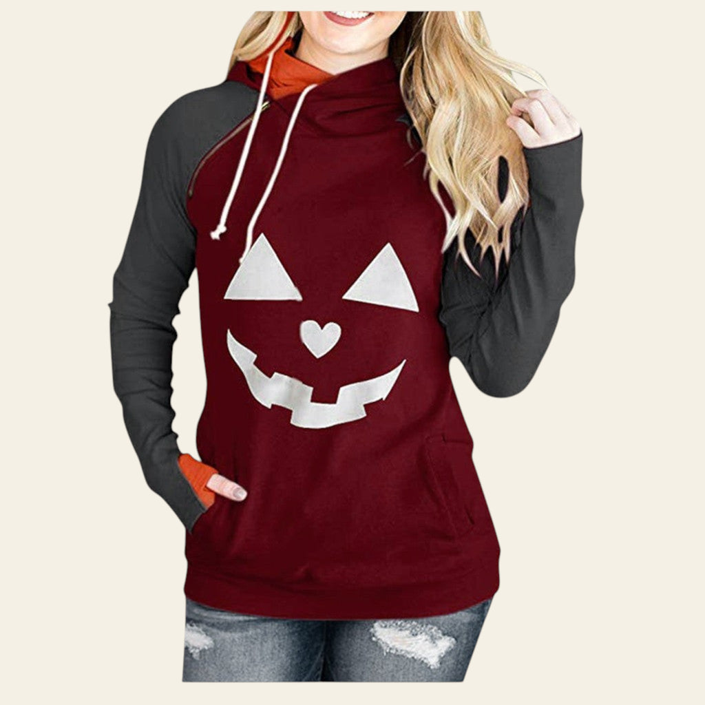 Maroon hoodie with pumpkin face design worn by a person on a white background