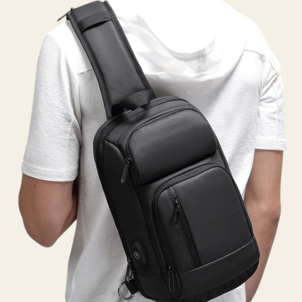 Person wearing a black sling bag on a gray background
