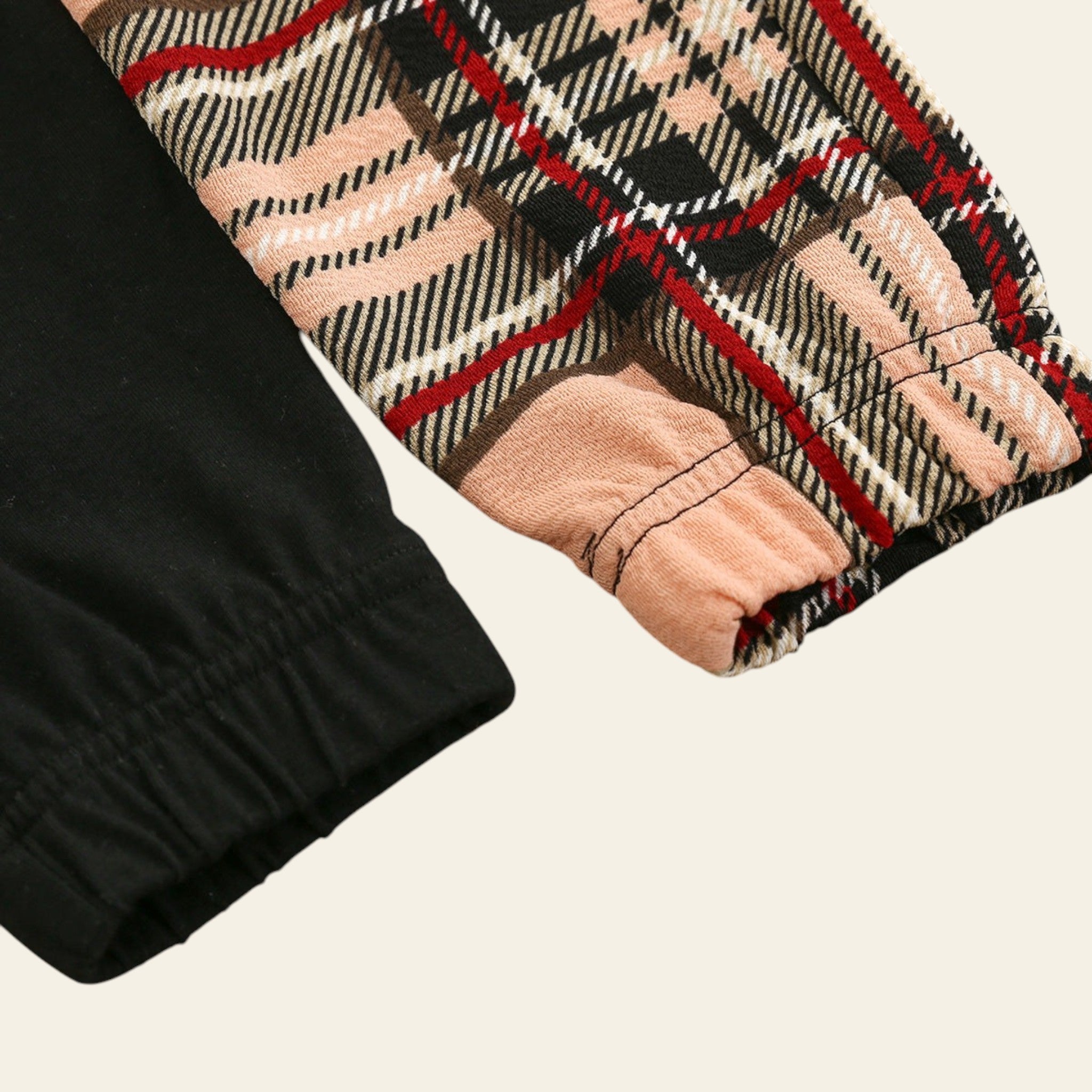 Plaid patterned fabric with black, red, and pink colors on a wooden surface
