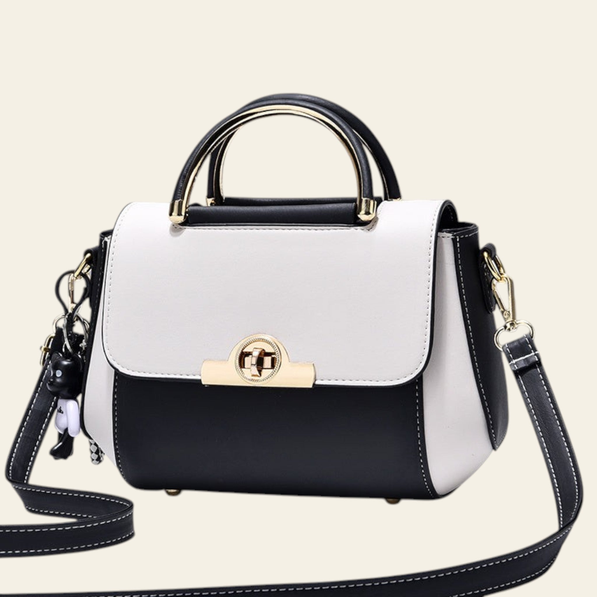 Black and white handbag with gold accents on a light gray background