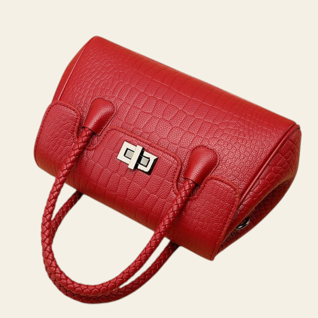 Red textured handbag with braided handle on a beige background