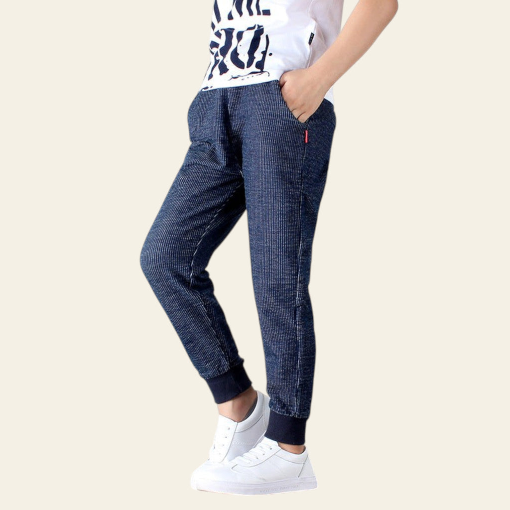 Person wearing blue checkered pants and white sneakers on a white background