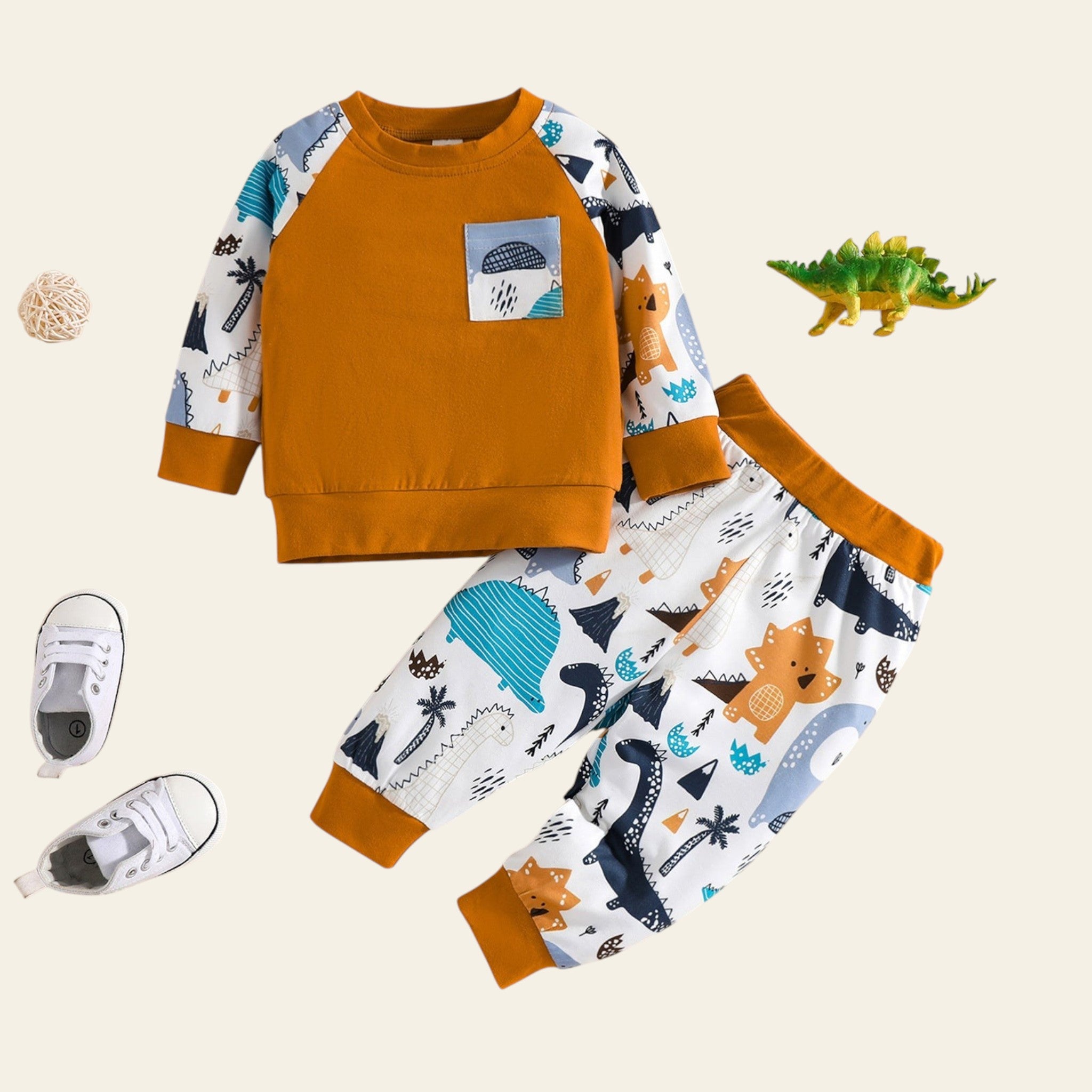 Children's outfit with orange long-sleeve shirt and patterned pants on a beige background