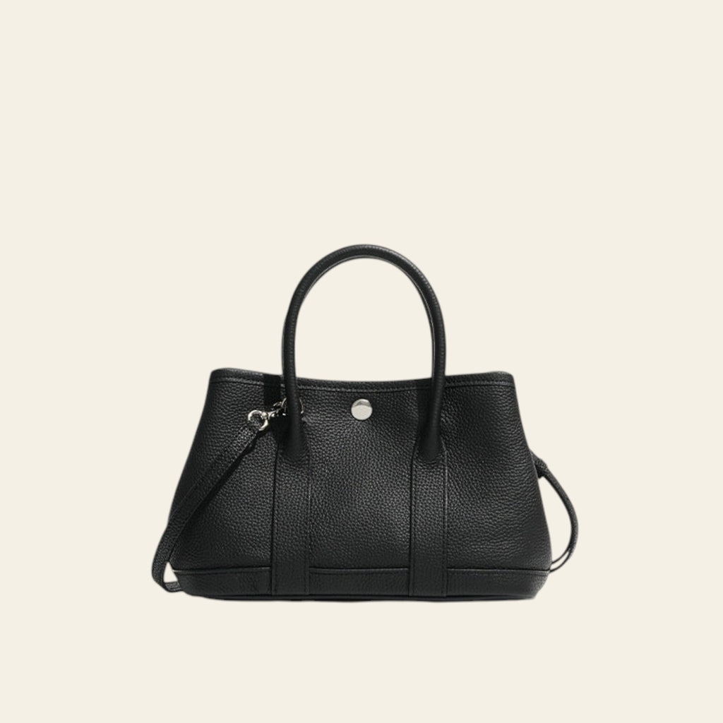 Black handbag with a strap on a white background