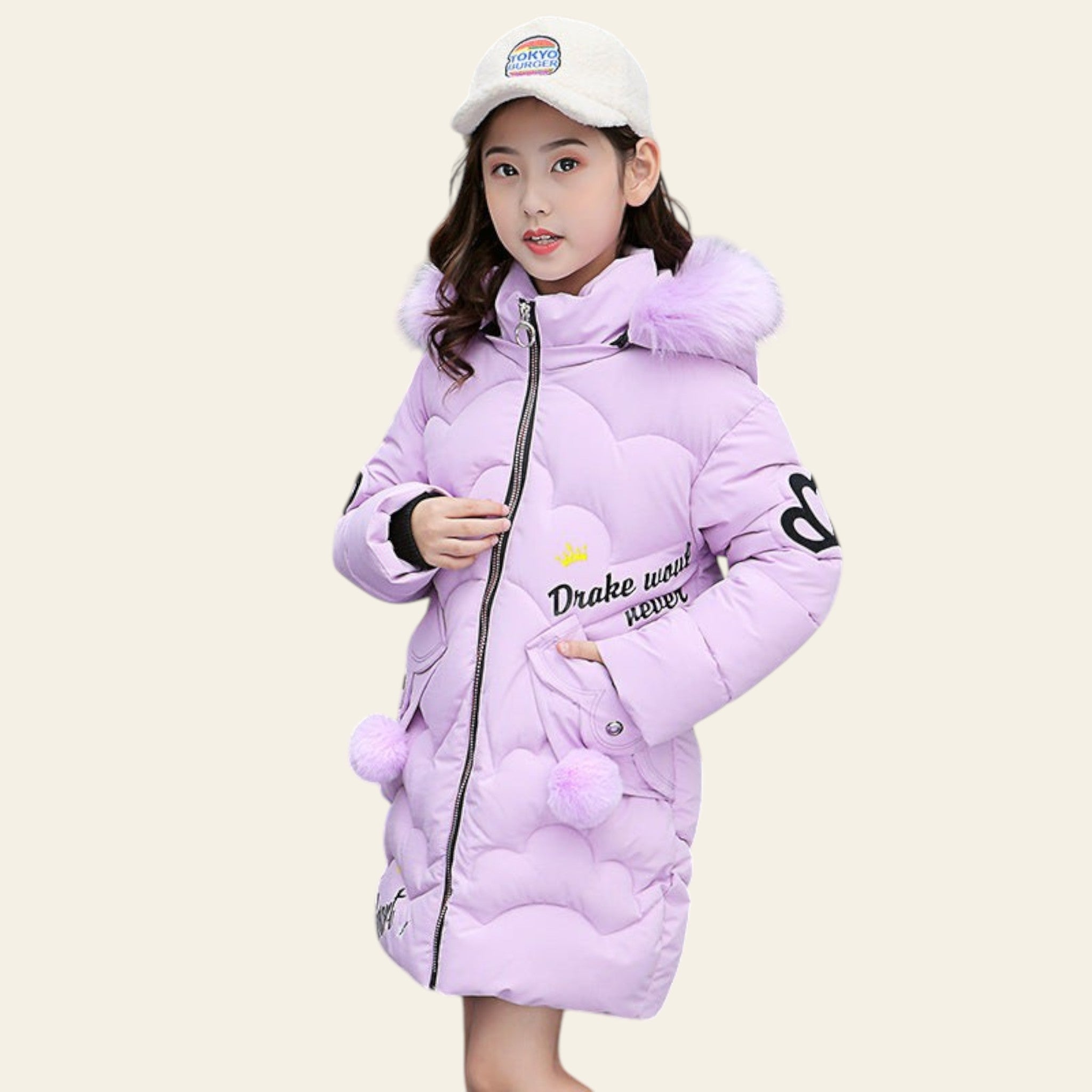 Child wearing a pink winter coat with pom-poms and a white cap outdoors.