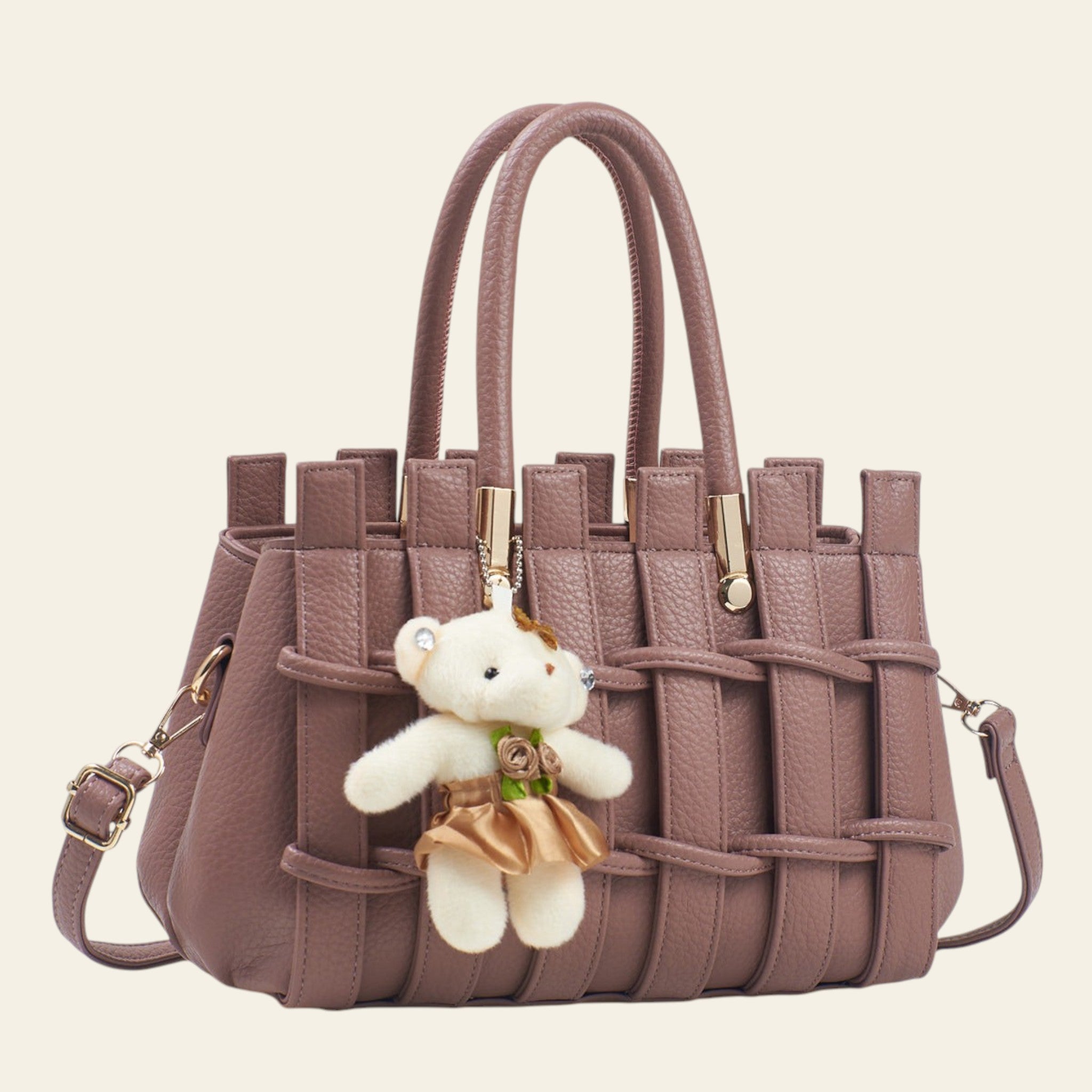 Pink woven handbag with a teddy bear charm on a light background