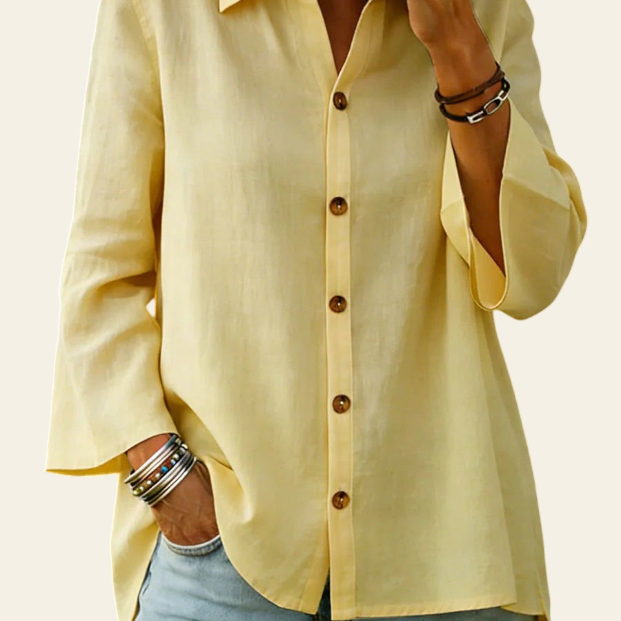 Person wearing a light yellow button-up shirt and blue jeans with a blurred background