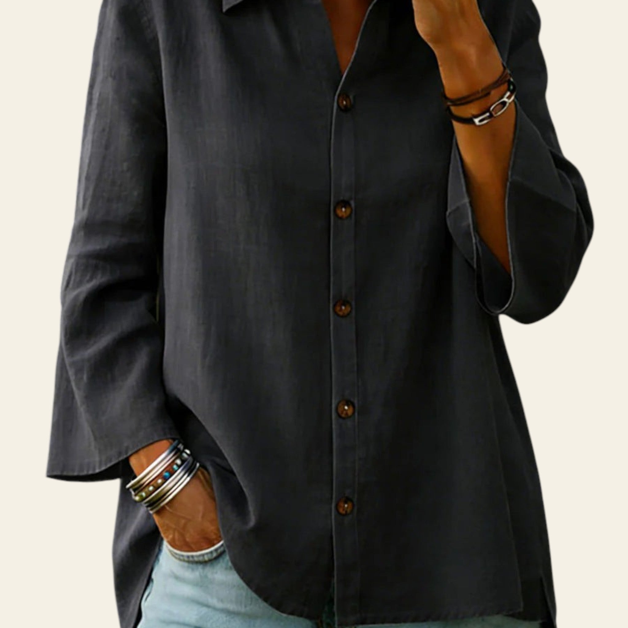 Person wearing a dark gray button-up shirt and light blue jeans with a blurred background