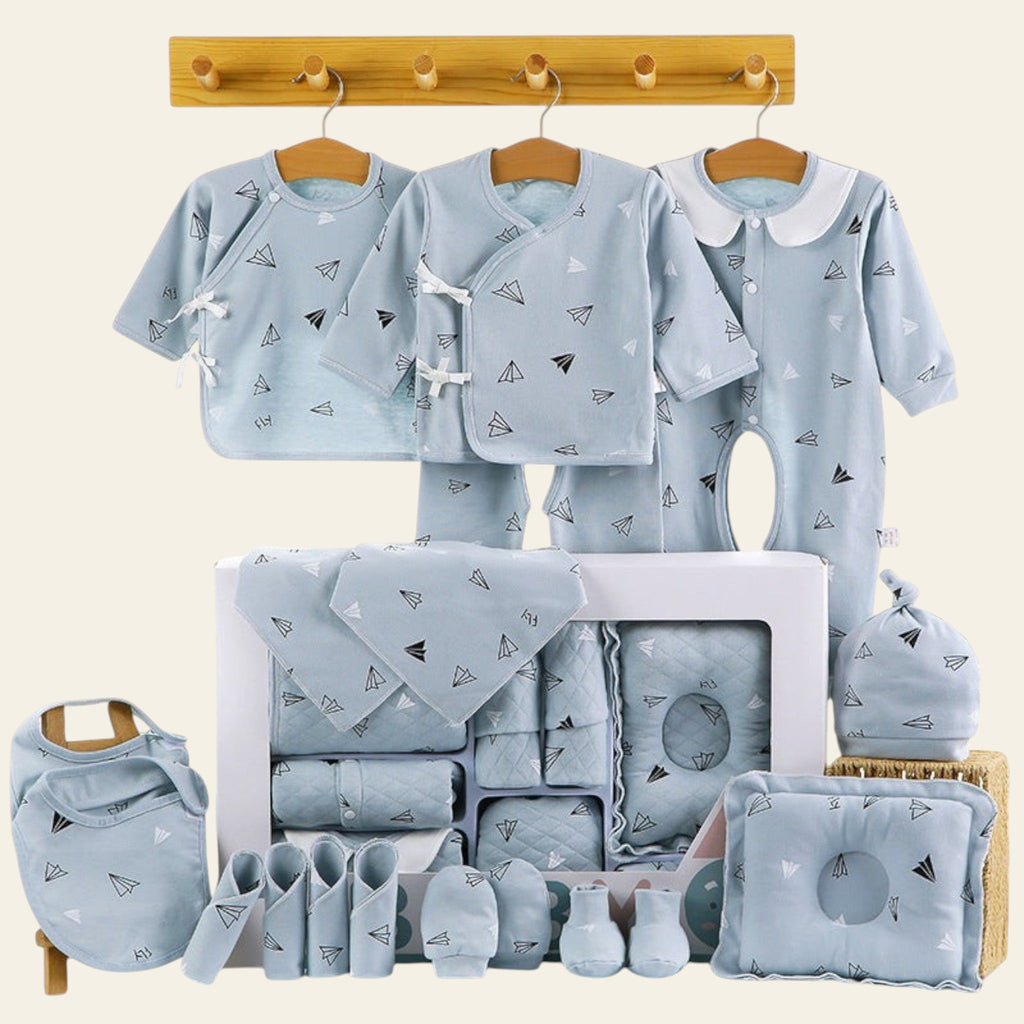 Collection of baby clothing and accessories with airplane pattern on a white background