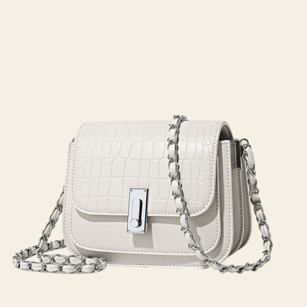 White handbag with a chain strap on a light beige background