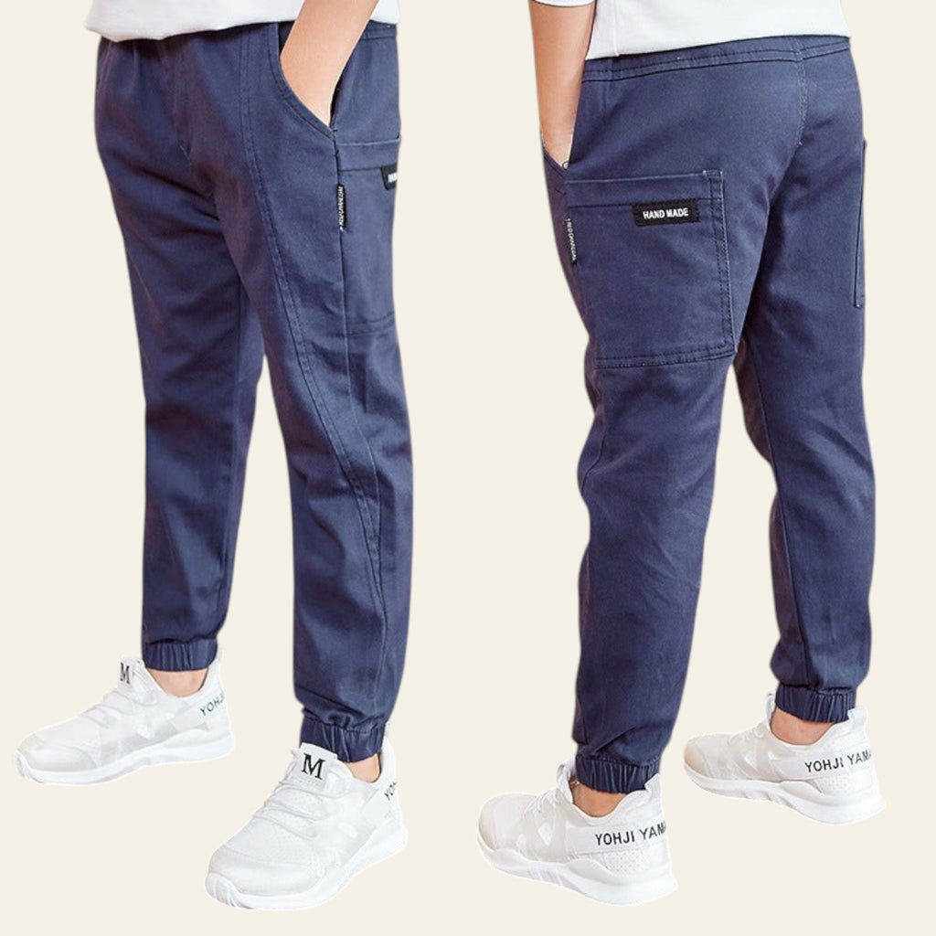 Navy jogger pants worn by a person on a wooden floor with a Starbucks sign in the background.