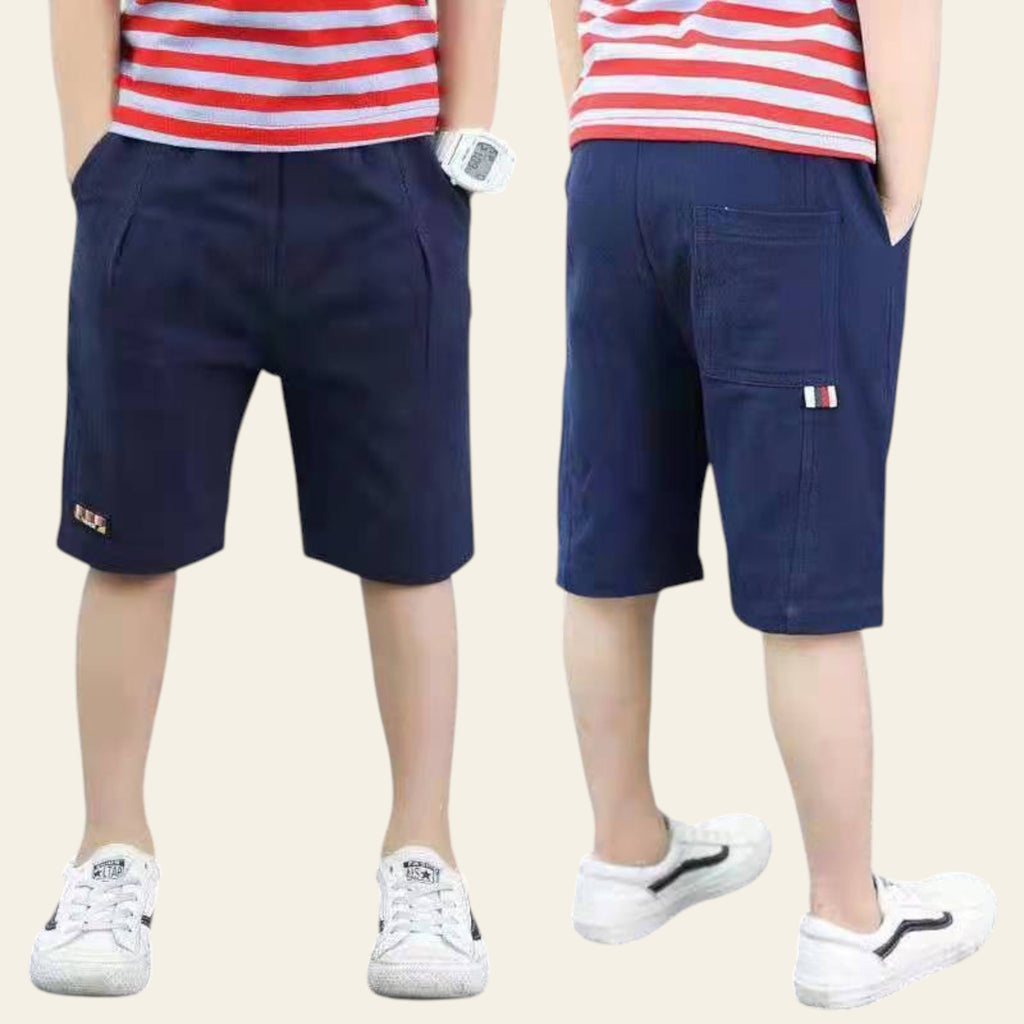 Two people wearing navy shorts and red and white striped shirts on a street.