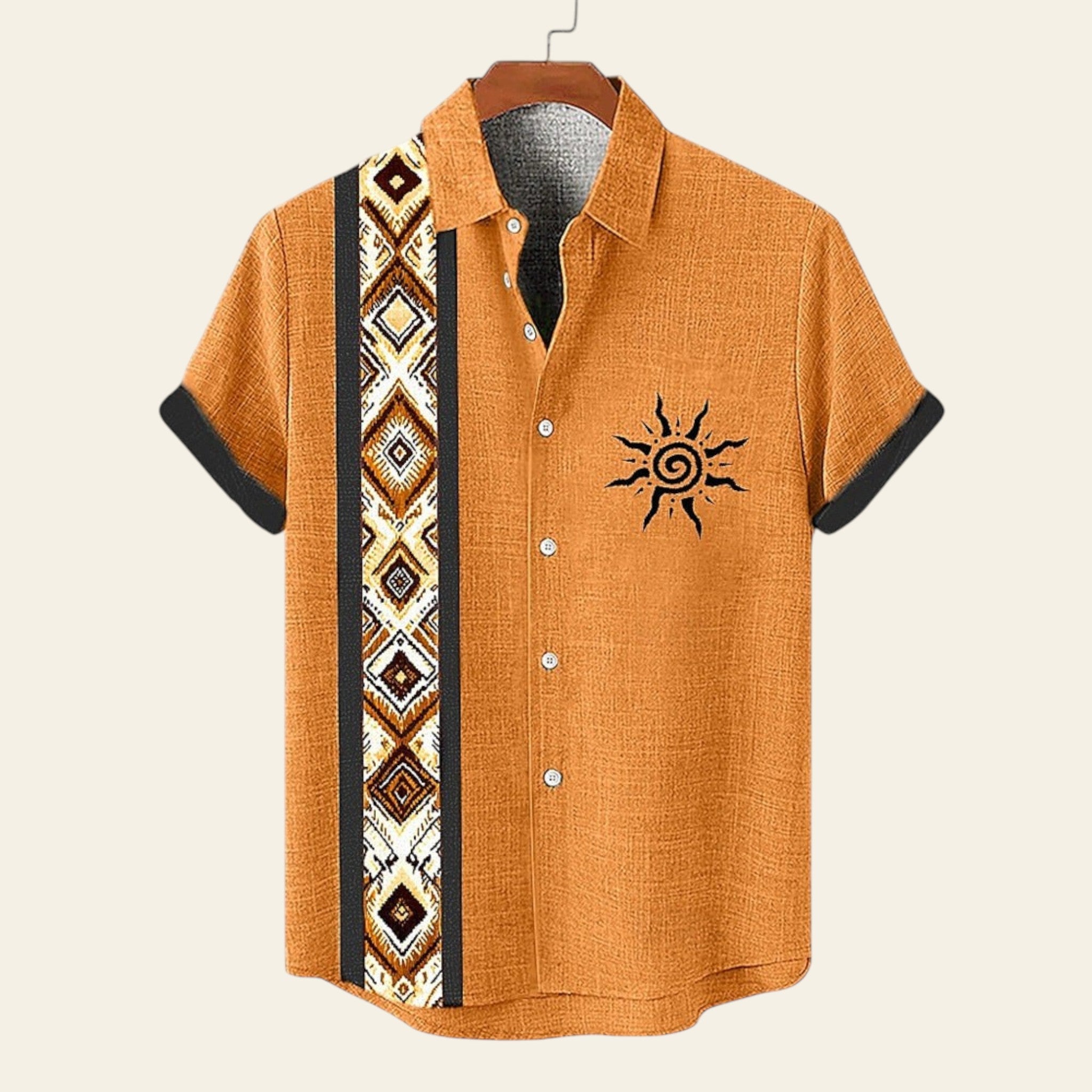Orange shirt with black sun design and geometric pattern on a hanger against a white background